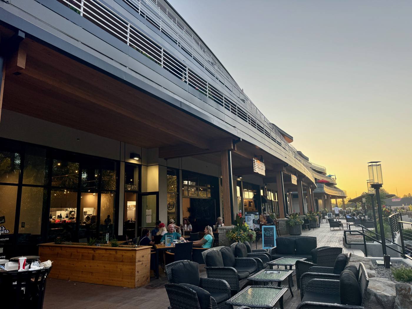 Boardwalk storefronts and patios lit at sunset